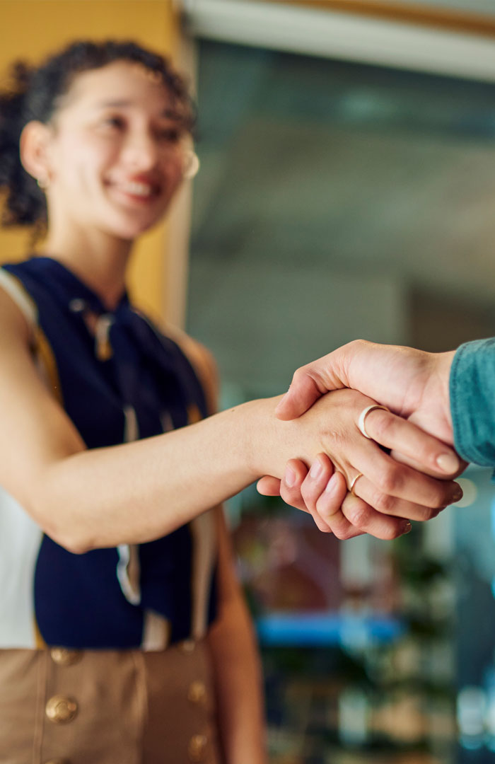 Lachende junge Frau mit rotem Shirt und rotem Lippenstift.